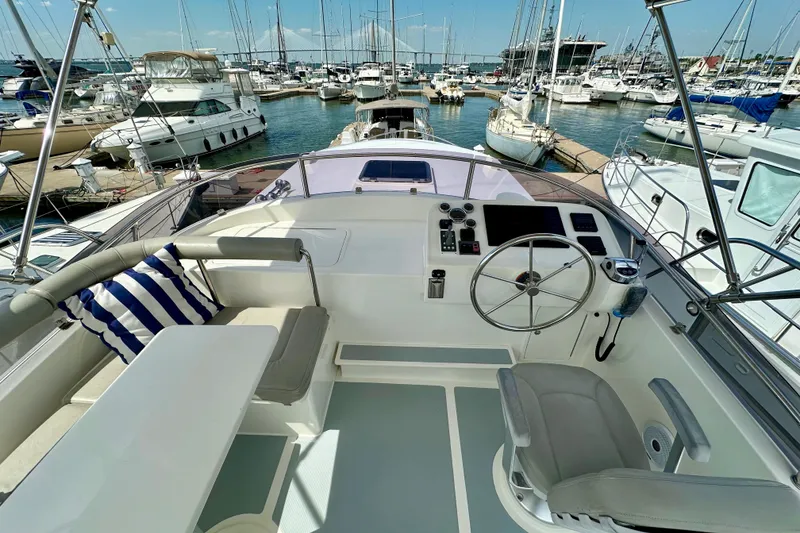 Slide: The Image of Helmsman Trawlers 38 Pilothouse 2016 yacht interior with steering wheel and marina view. - 34