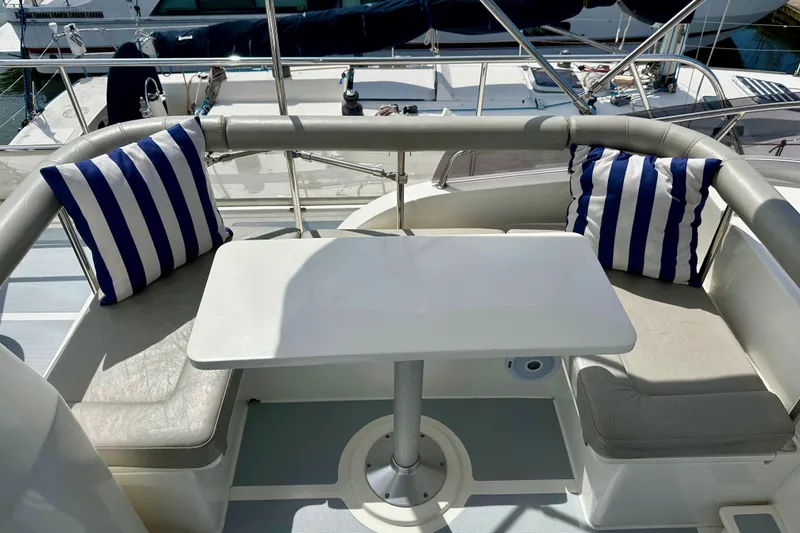 Slide: The Image of Helmsman Trawlers 38 Pilothouse 2016 boat seating area with striped cushions and table. - 35