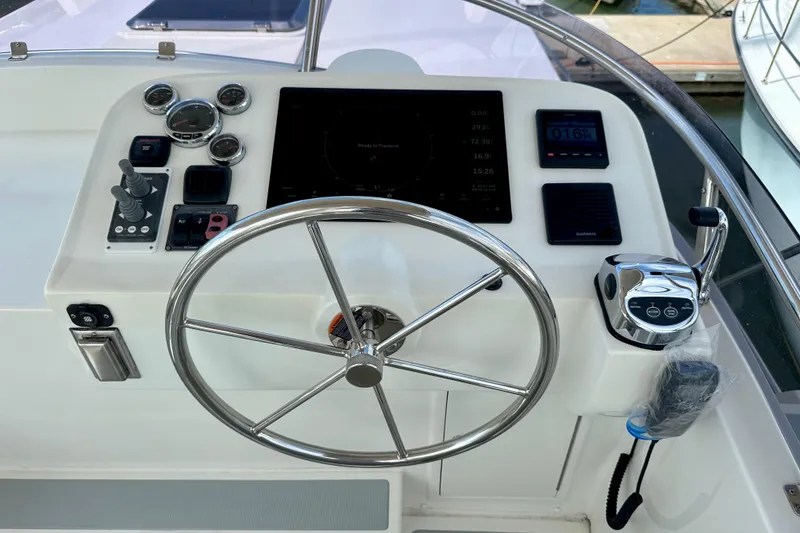 Slide: The Image of Helmsman Trawlers 38 Pilothouse 2016 helm with steering wheel and navigation controls. - 36