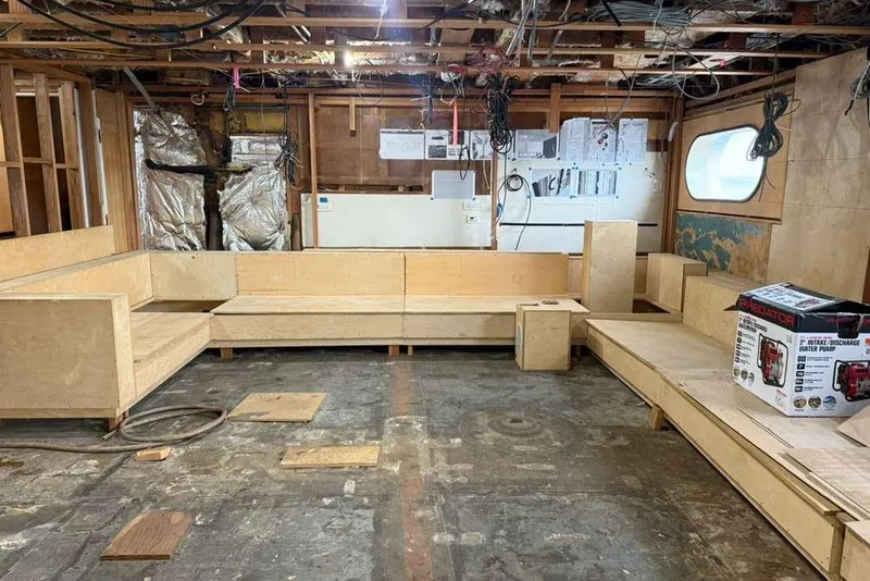 Slide: The Image of Interior renovation of 1985 Sterling Yachts 155 Motor Yacht, featuring unfinished wooden seating and exposed wiring. - 39