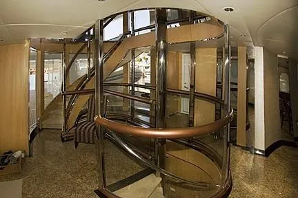 Slide: The Image of Luxurious spiral staircase inside 1985 Sterling Yachts 155 Motor Yacht, featuring elegant wood and metal design. - 4