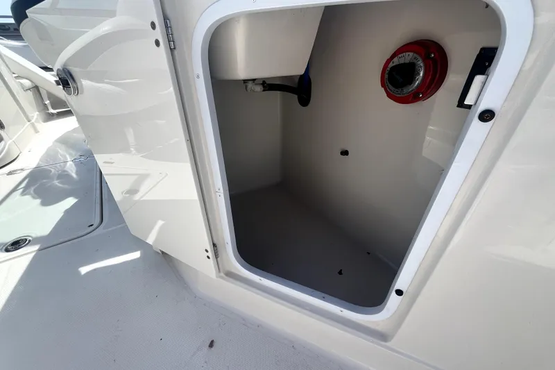 Slide: The Image of Open storage compartment on a 2011 Monterey 254FSC boat, featuring a red dial. - 15