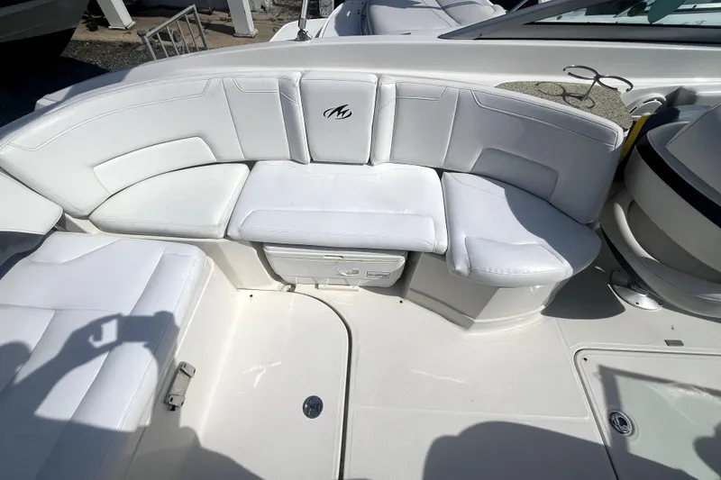 Slide: The Image of 2011 Monterey 254FSC boat interior with white cushioned seating and storage compartment. - 18