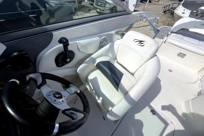 Slide: The Image of Interior of a 2011 Monterey 254FSC boat featuring steering wheel and captain's chair. - 21