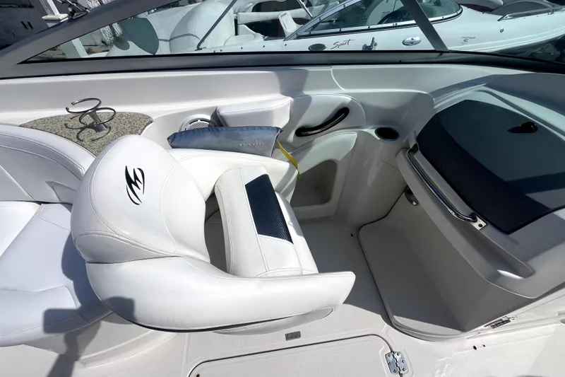 Slide: The Image of Interior of a 2011 Monterey 254FSC boat with white seating and dashboard. - 23