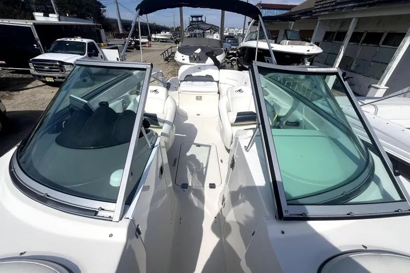 Slide: The Image of 2011 Monterey 254FSC boat with open cockpit and windshield, parked outdoors. - 26