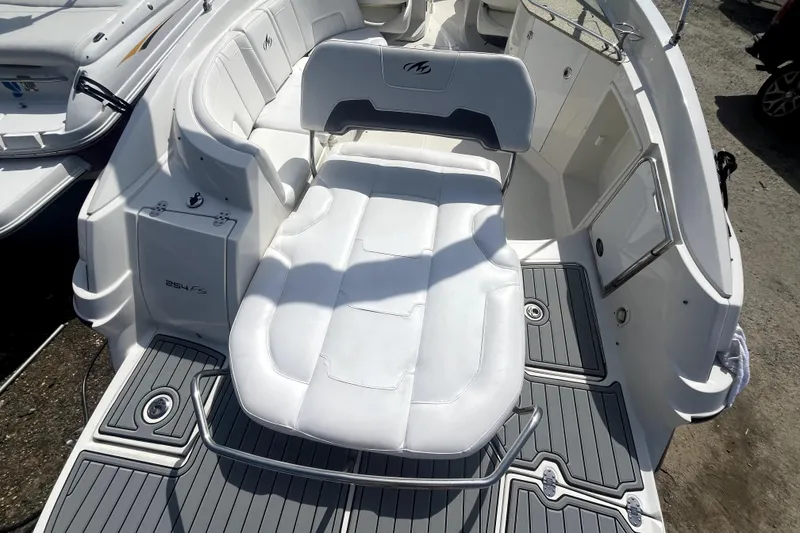 Slide: The Image of 2011 Monterey 254FSC boat interior with white seating and gray flooring. - 8