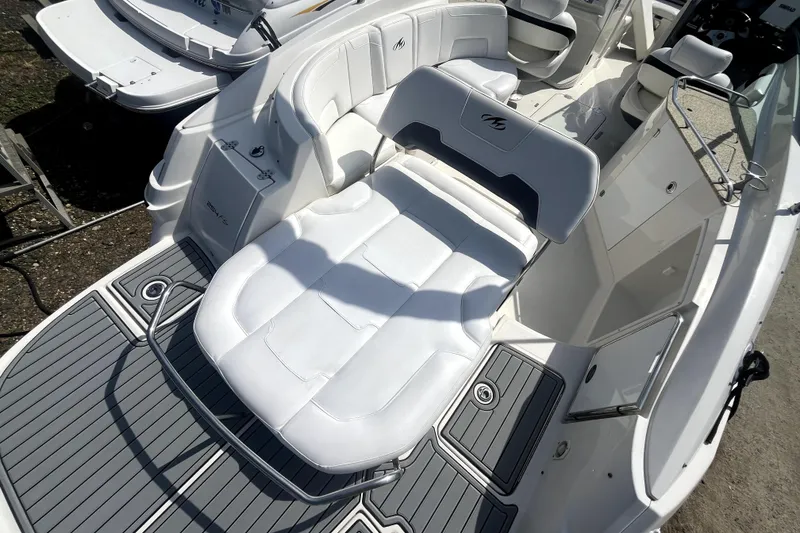 Slide: The Image of 2011 Monterey 254FSC boat interior with white seating and gray flooring. - 9