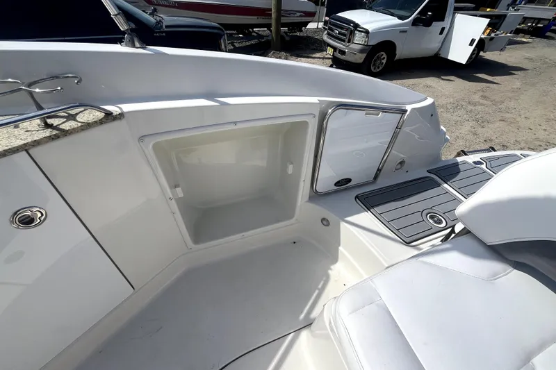 Slide: The Image of 2011 Monterey 254FSC boat interior with open storage compartment and seating area. - 12