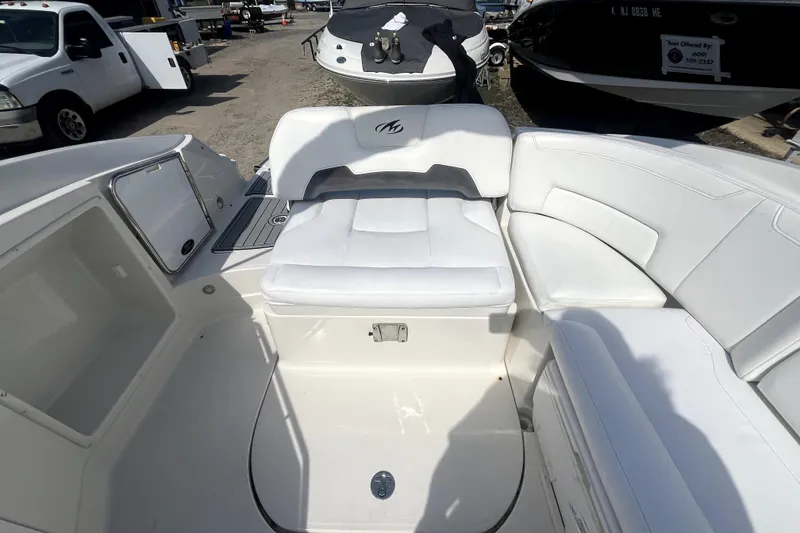 Slide: The Image of 2011 Monterey 254FSC boat interior with white seating and storage compartments. - 17