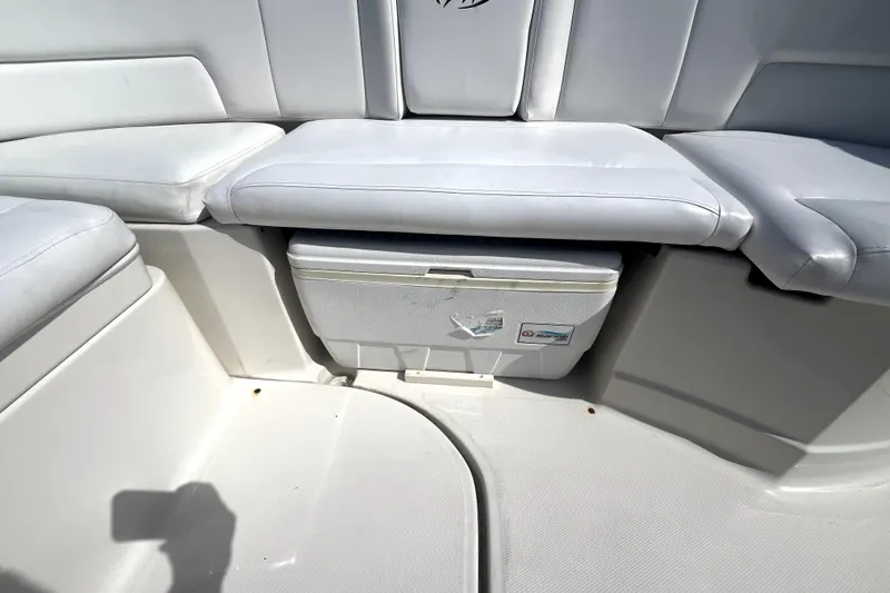 Slide: The Image of White seating area with built-in cooler on a 2011 Monterey 254FSC boat. - 19