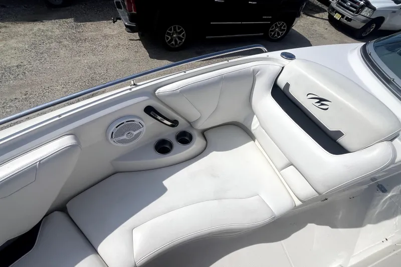Slide: The Image of White leather seating on a 2011 Monterey 254FSC boat with cup holders and speaker. - 28