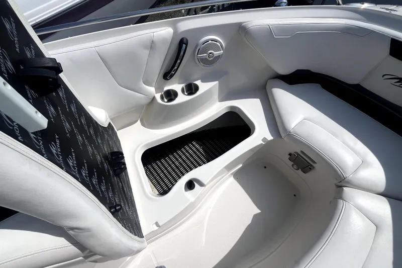 Slide: The Image of Interior of a 2011 Monterey 254FSC boat featuring white seating and cup holders. - 29