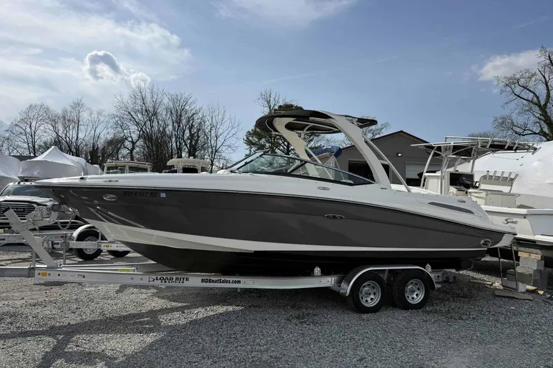 The Image of 2008 Sea Ray SLX 250 boat on trailer, parked outdoors under clear sky. - 0