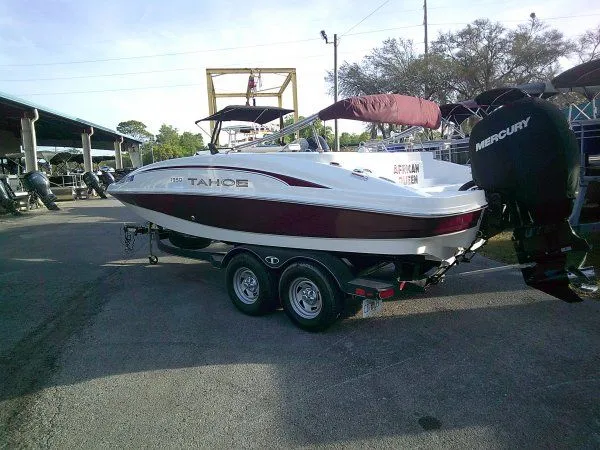 The Image of 2019 Tahoe 1950 Deck boat parked outdoors on a trailer. - 1