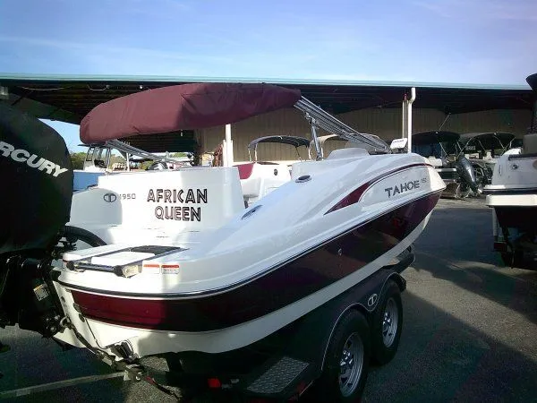 Slide: The Image of 2019 Tahoe 1950 Deck boat with red canopy on trailer. - 3