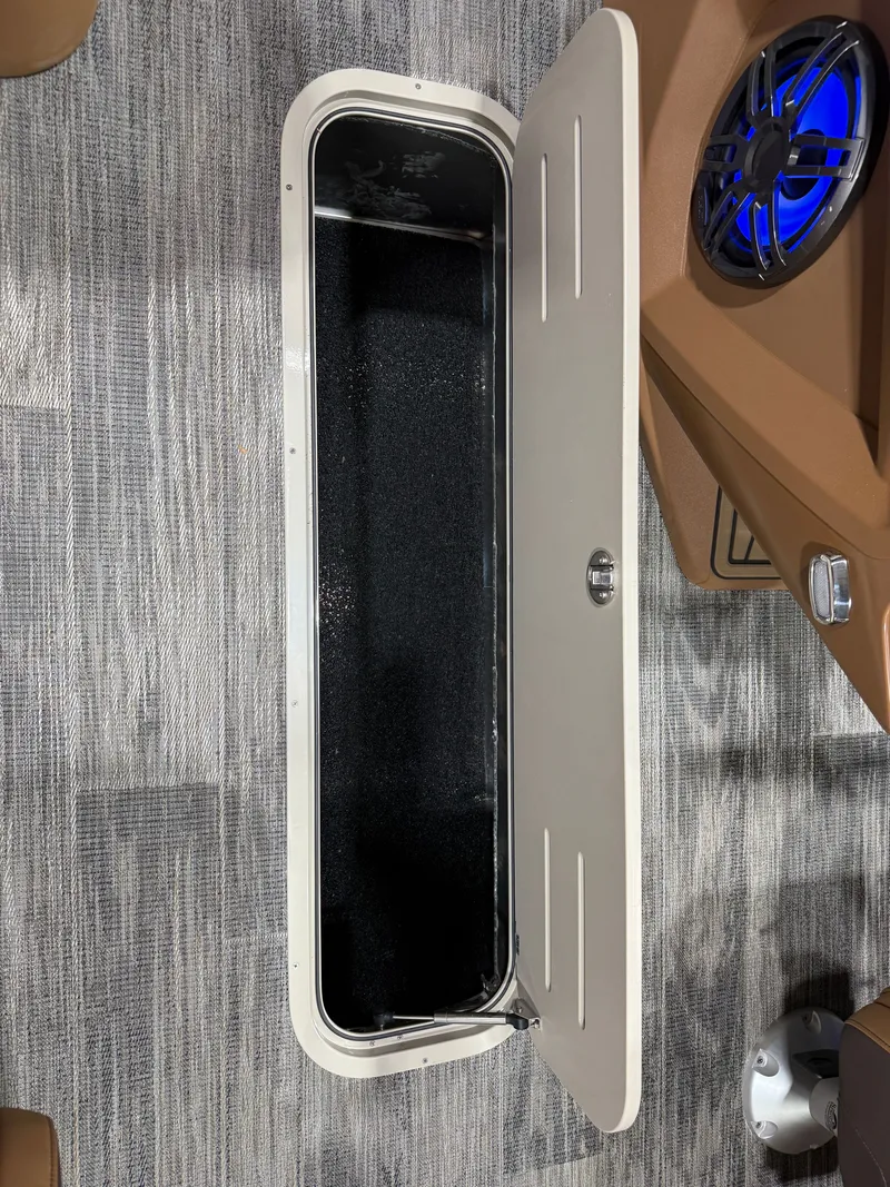 Slide: The Image of Open storage compartment in 2025 Tahoe Cascade 2385 Tritoon boat. - 33