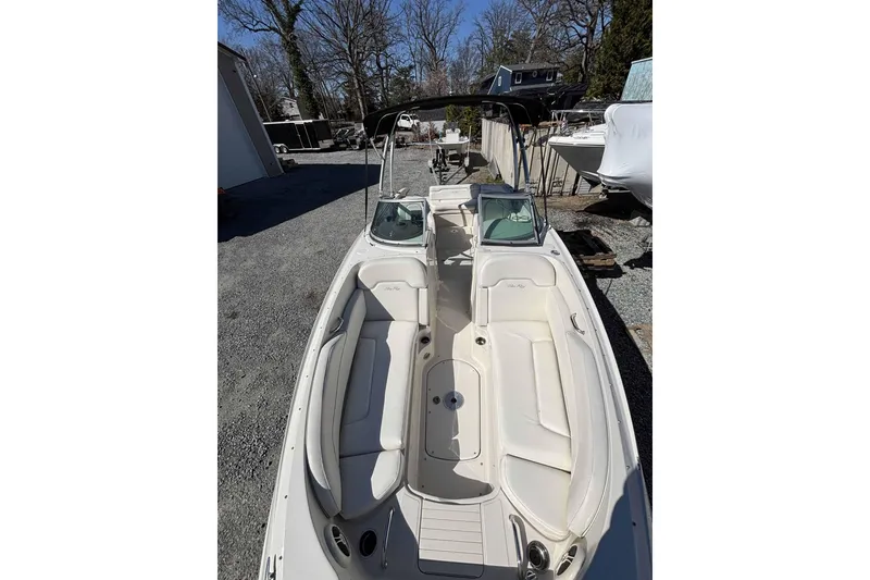 Slide: The Image of 2008 Sea Ray 260 Sundeck boat with white seating, parked outdoors. - 6