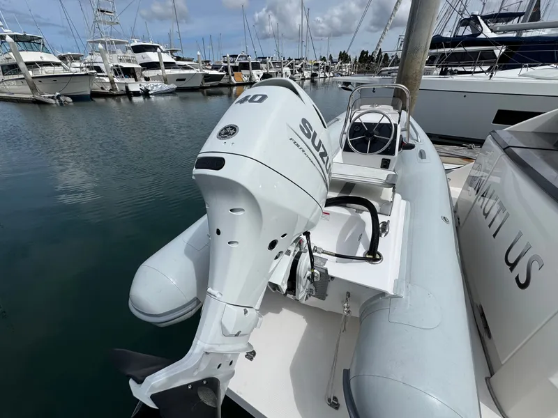 Slide: The Image of Suzuki outboard motor on an inflatable boat at the marina. - 27