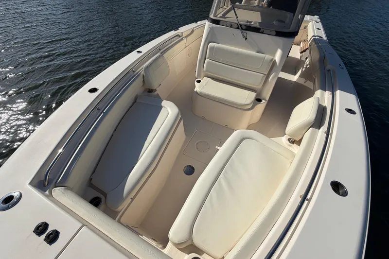 Slide: The Image of 2018 Grady-White Canyon 306 boat interior with cushioned seating on calm water. - 13