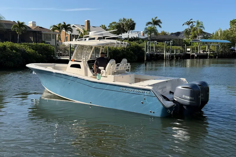 Slide: The Image of 2018 Grady-White Canyon 306 boat on calm water, featuring twin Yamaha engines. - 2