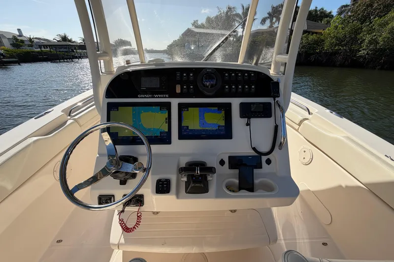 Slide: The Image of 2018 Grady-White Canyon 306 boat dashboard with navigation screens and steering wheel. - 23