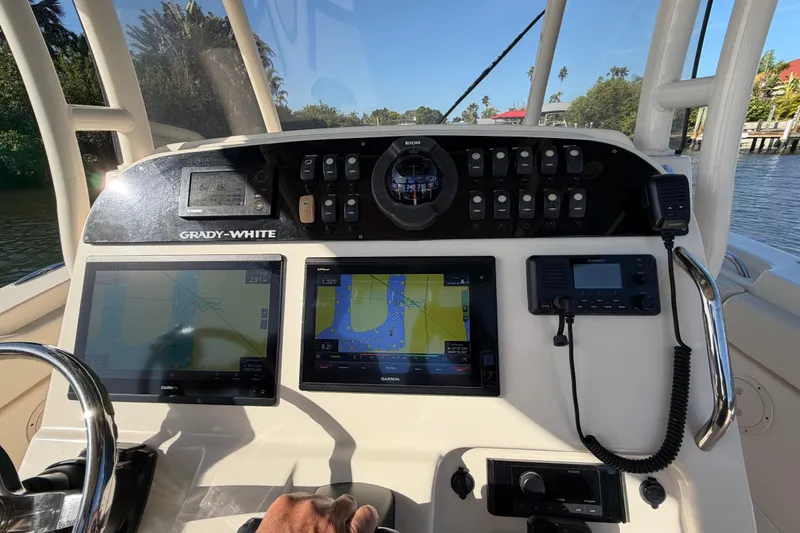 Slide: The Image of 2018 Grady-White Canyon 306 boat dashboard with navigation screens and controls. - 24