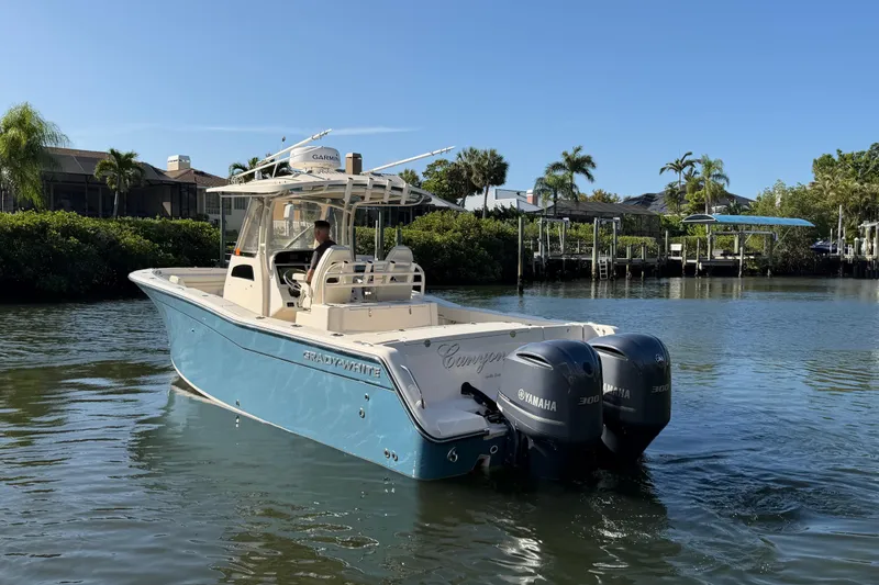 Slide: The Image of 2018 Grady-White Canyon 306 boat with twin Yamaha engines on a calm waterway. - 3