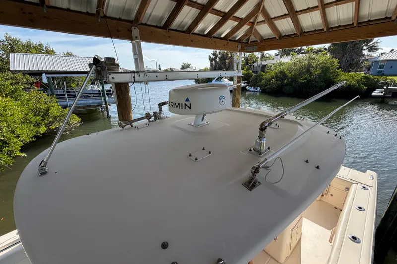 Slide: The Image of 2018 Grady-White Canyon 306 boat with Garmin radar, docked under a wooden canopy. - 37