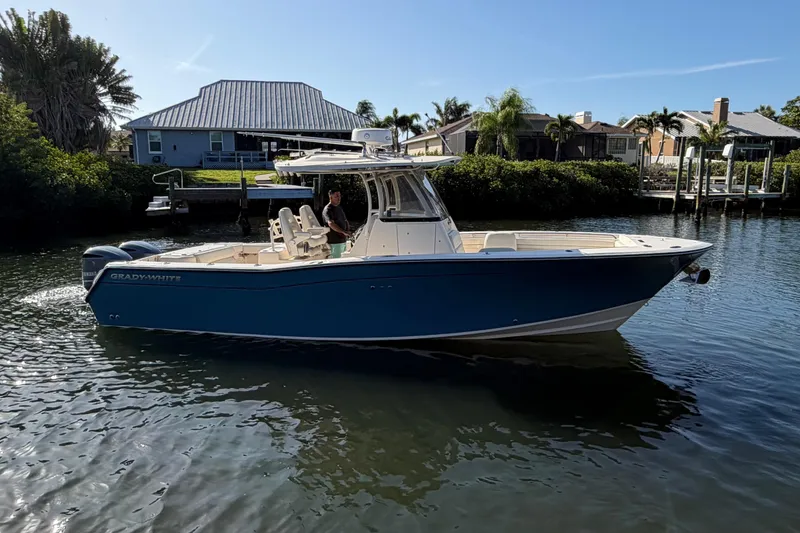 Slide: The Image of 2018 Grady-White Canyon 306 boat on calm water near residential docks. - 4