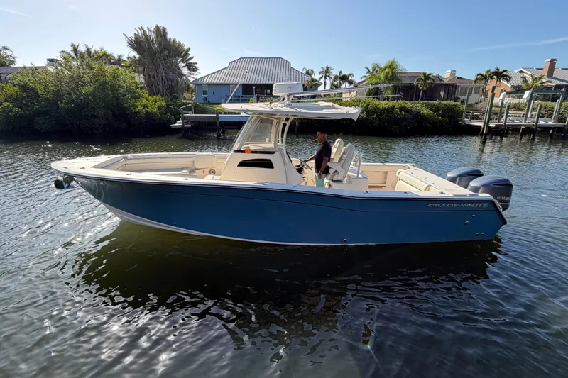 Slide: The Image of 2018 Grady-White Canyon 306 boat on calm water, surrounded by lush greenery. - 5