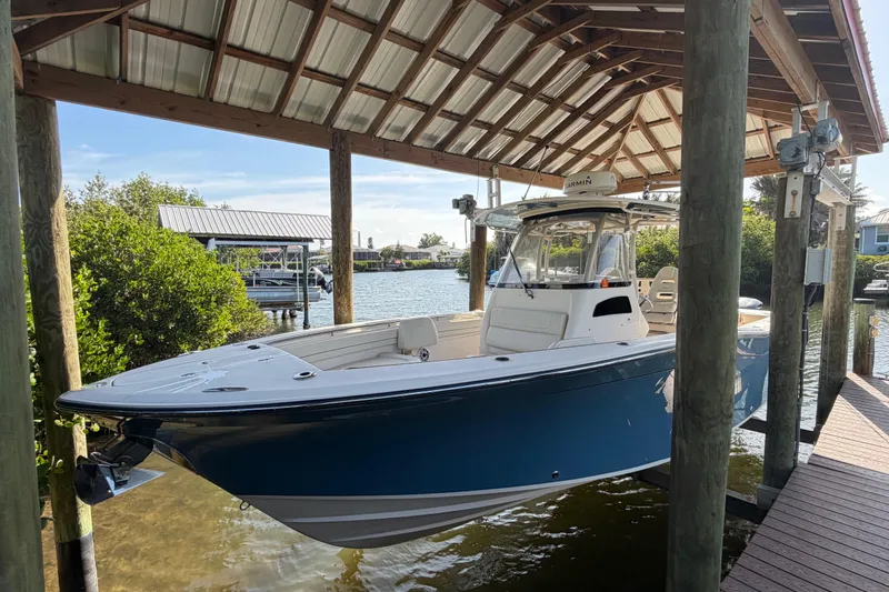 Slide: The Image of 2018 Grady-White Canyon 306 boat docked under a wooden shelter by the water. - 8