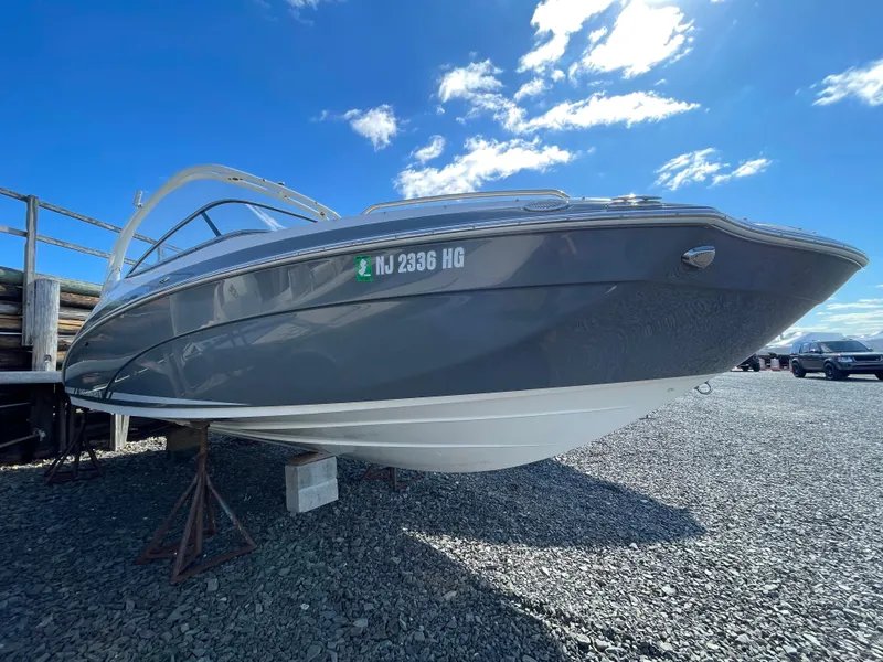 Slide: The Image of 2015 Yamaha Boats 242 Limited S on gravel lot under blue sky. - 1