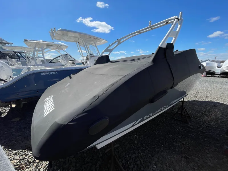 Slide: The Image of 2015 Yamaha Boats 242 Limited S with cover on gravel lot. - 18
