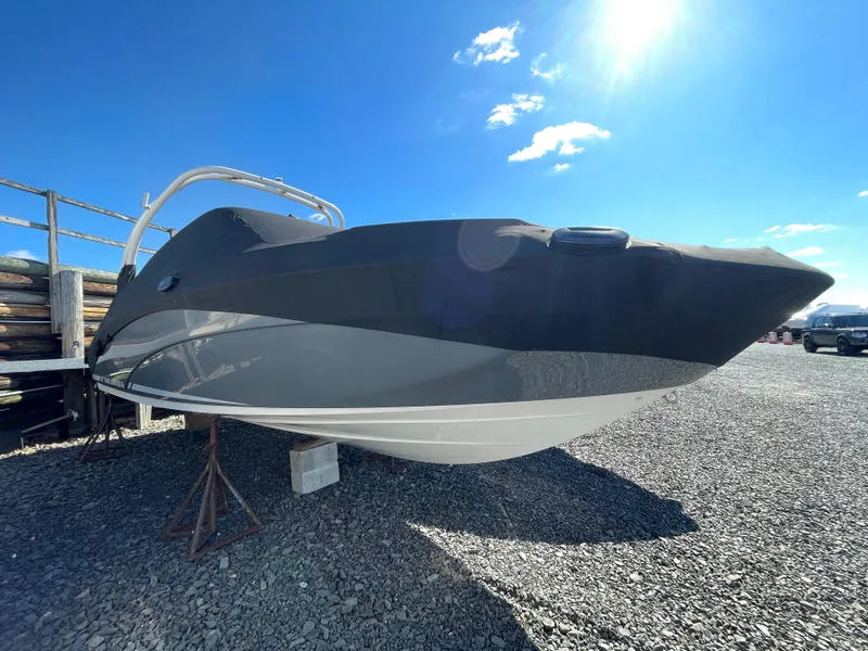 Slide: The Image of 2015 Yamaha Boats 242 Limited S on gravel lot under sunny sky. - 19