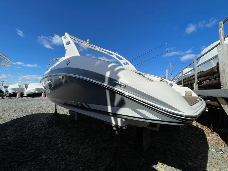 Slide: The Image of 2015 Yamaha Boats 242 Limited S on gravel lot under blue sky. - 3