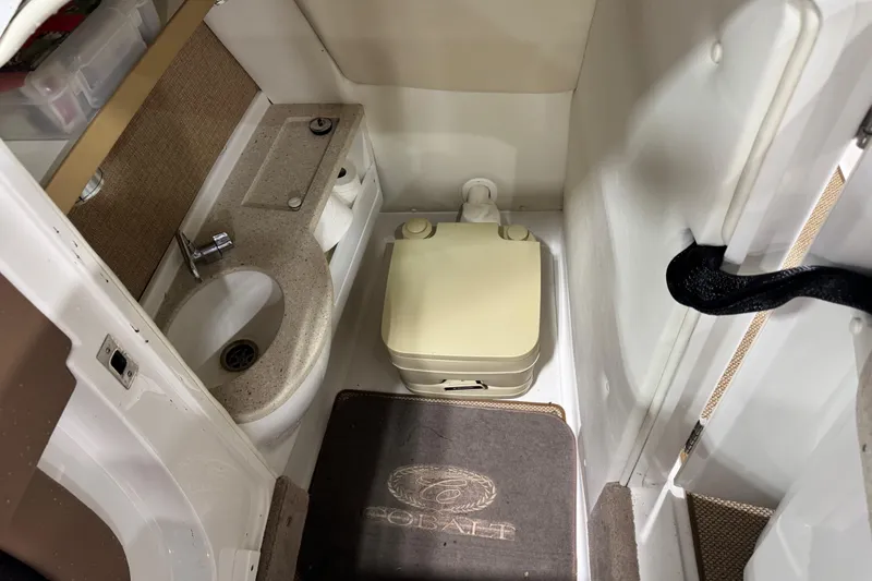 Slide: The Image of Compact bathroom in a 2014 Cobalt 276 boat with sink and portable toilet. - 12