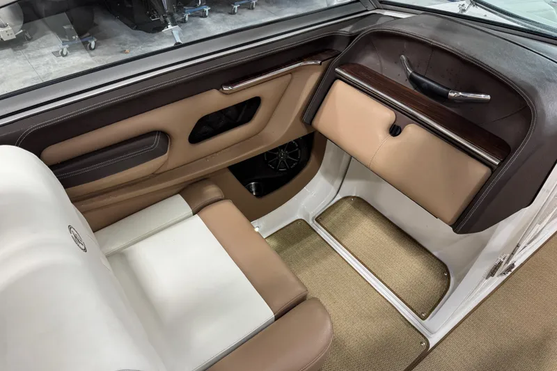 Slide: The Image of Interior of a 2014 Cobalt 276 boat, featuring tan and white seating with wood accents. - 13