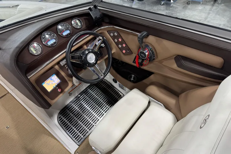 Slide: The Image of 2014 Cobalt 276 boat cockpit with steering wheel, gauges, and navigation system. - 14