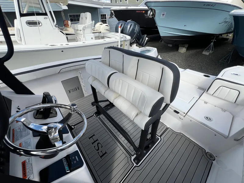 Slide: The Image of Interior of 2023 Yamaha 255 FSH Sport E boat with steering wheel and bench seating. - 20