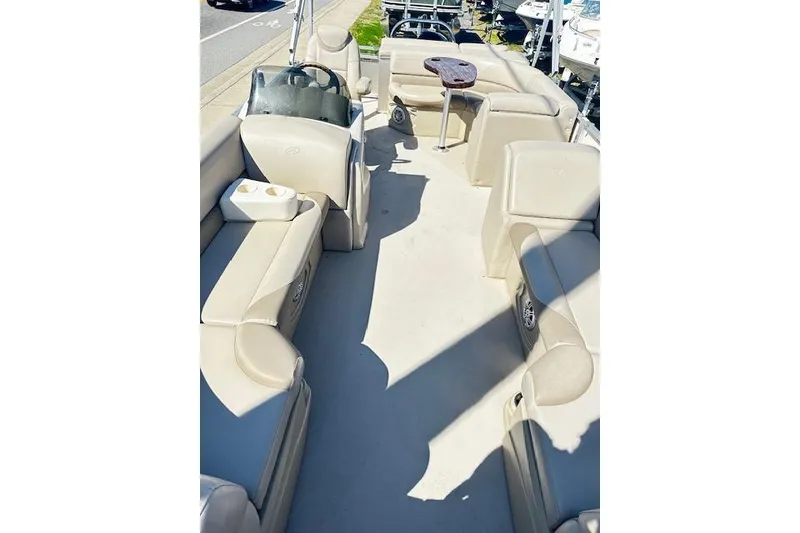 Slide: The Image of 2016 Avalon LSV Tri Toon boat interior with beige seating and steering console. - 3
