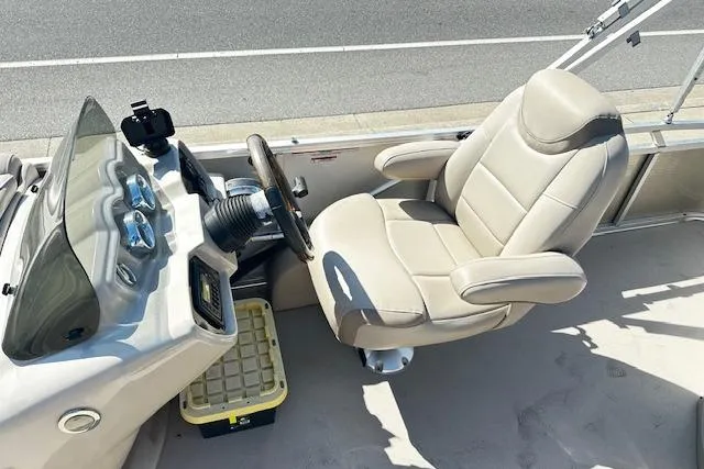 Slide: The Image of 2016 Avalon LSV Tri Toon boat cockpit with beige captain's chair and steering console. - 5