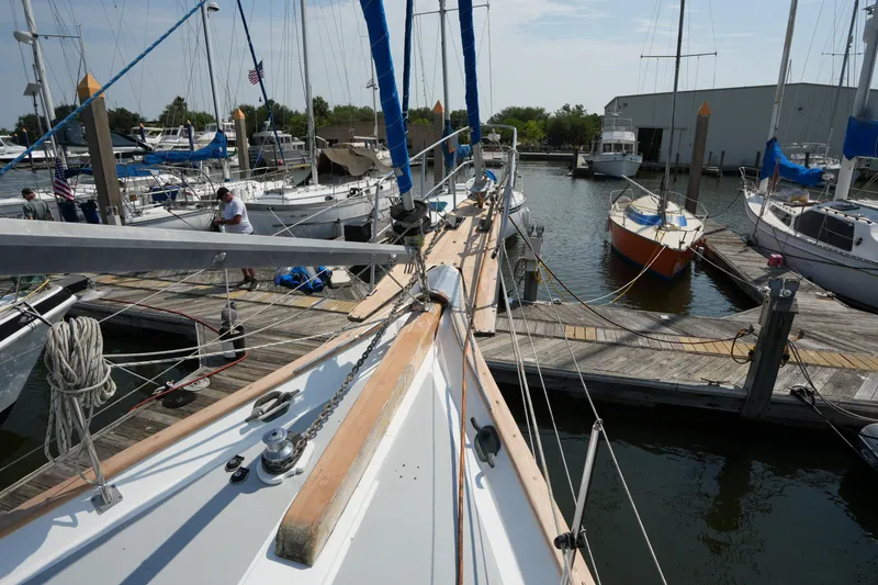 Slide: The Image of 1982 Vagabond 47 sailboat docked at marina with other boats and clear sky. - 11