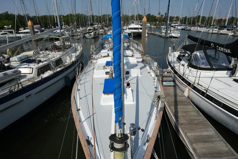 Slide: The Image of 1982 Vagabond 47 sailboat docked at marina, surrounded by other boats. - 12