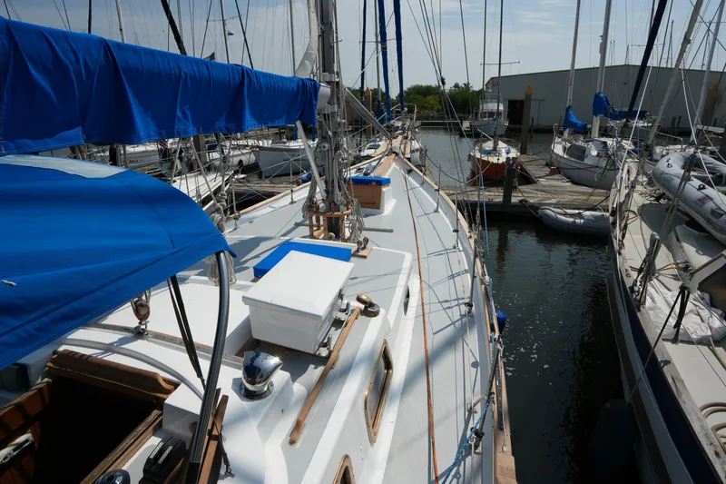 Slide: The Image of Sailboat docked at marina, Vagabond 47 model, 1982, with blue covers and clear sky. - 13