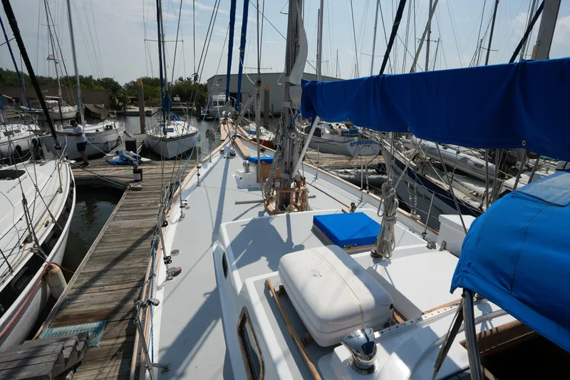 Slide: The Image of Sailboat docked at marina, Vagabond 47 model, 1982, with blue covers and clear sky. - 14