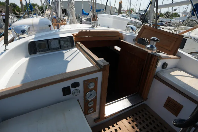 Slide: The Image of Cockpit of 1982 Vagabond 47 sailboat with navigation instruments and wooden hatch. - 17