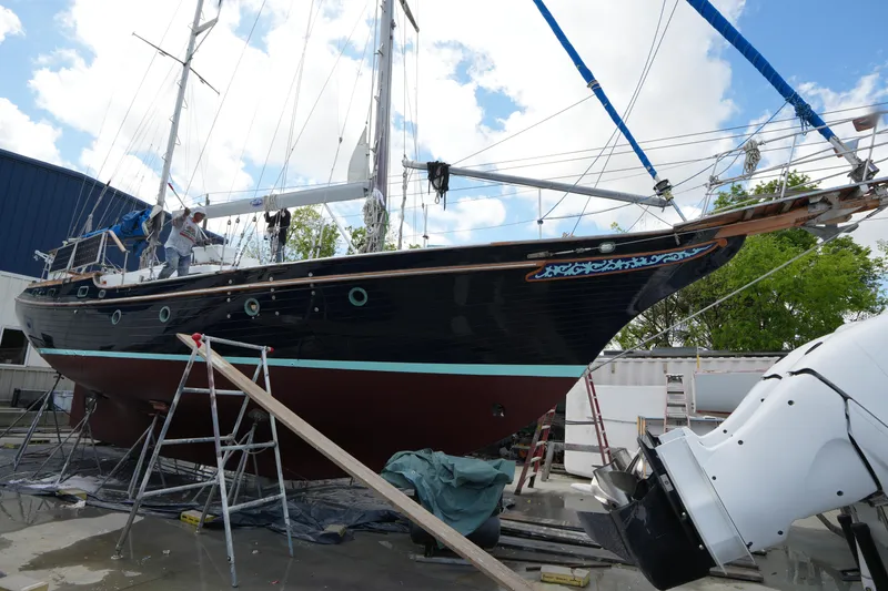 Slide: The Image of 1982 Vagabond 47 sailboat undergoing maintenance on dry dock with clear sky background. - 2