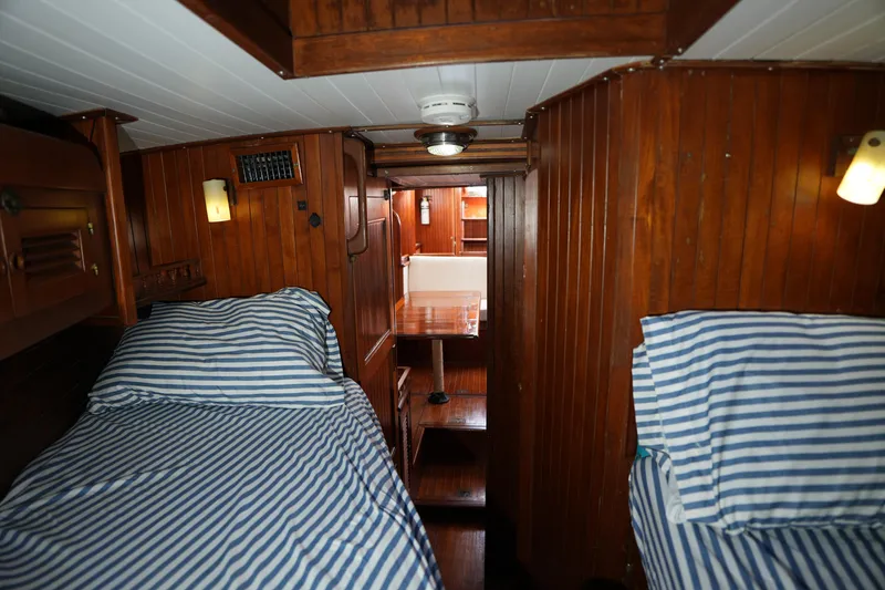 Slide: The Image of Cozy wooden interior of 1982 Vagabond 47 sailboat with striped bedding and warm lighting. - 23