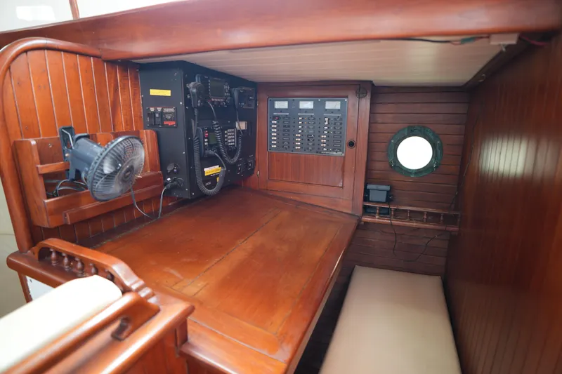 Slide: The Image of Wooden interior of 1982 Vagabond 47 sailboat with navigation equipment and porthole. - 26